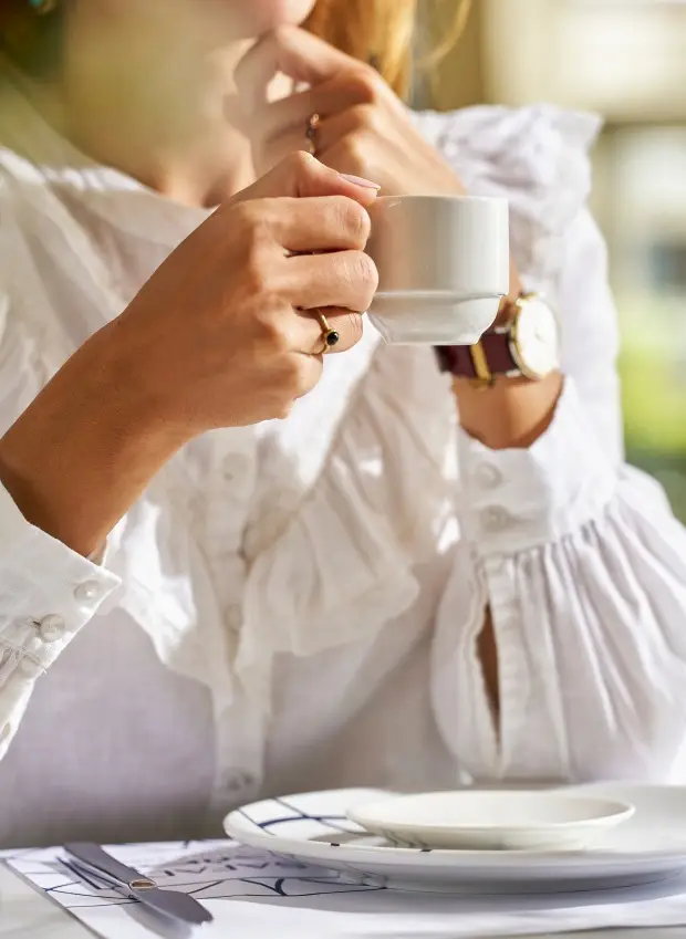 the woman drinks coffee at the table